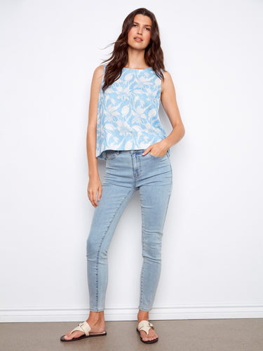 This relaxed fit top features a charming floral pattern on blue fabric, ideal for warm weather styling. By Charlie B.