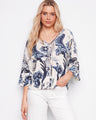 Elegant blouse with a V-neck and wide 3/4 sleeves, showcasing intricate ladder stitch detail by Charlie B.