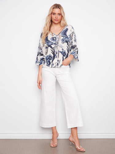 Chic V-neck blouse adorned with a colorful pattern and ladder stitch accents for added style by Charlie B.