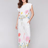 White pants with a smocked waistband and floral border print by Charlie B.