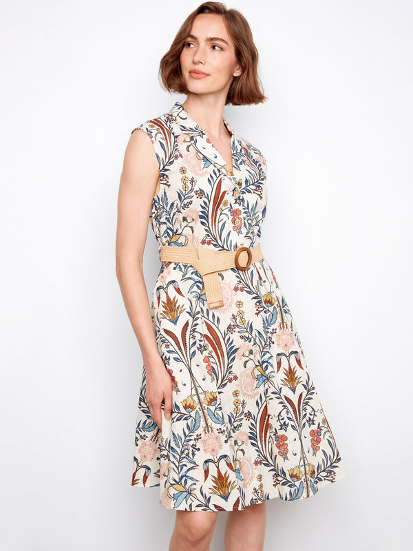 Stylish dress with a straw belt enhancing the waist, adding a natural touch to the floral design. By Charlie B.