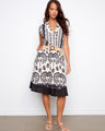 Black and white printed dress with a tailored neckline and straw belt, featuring cap sleeves and knee-length design by Charlie B.