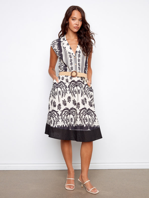 Stylish black and white dress showcasing a half-button design, complete with slash pockets and cap sleeves by Charlie B.