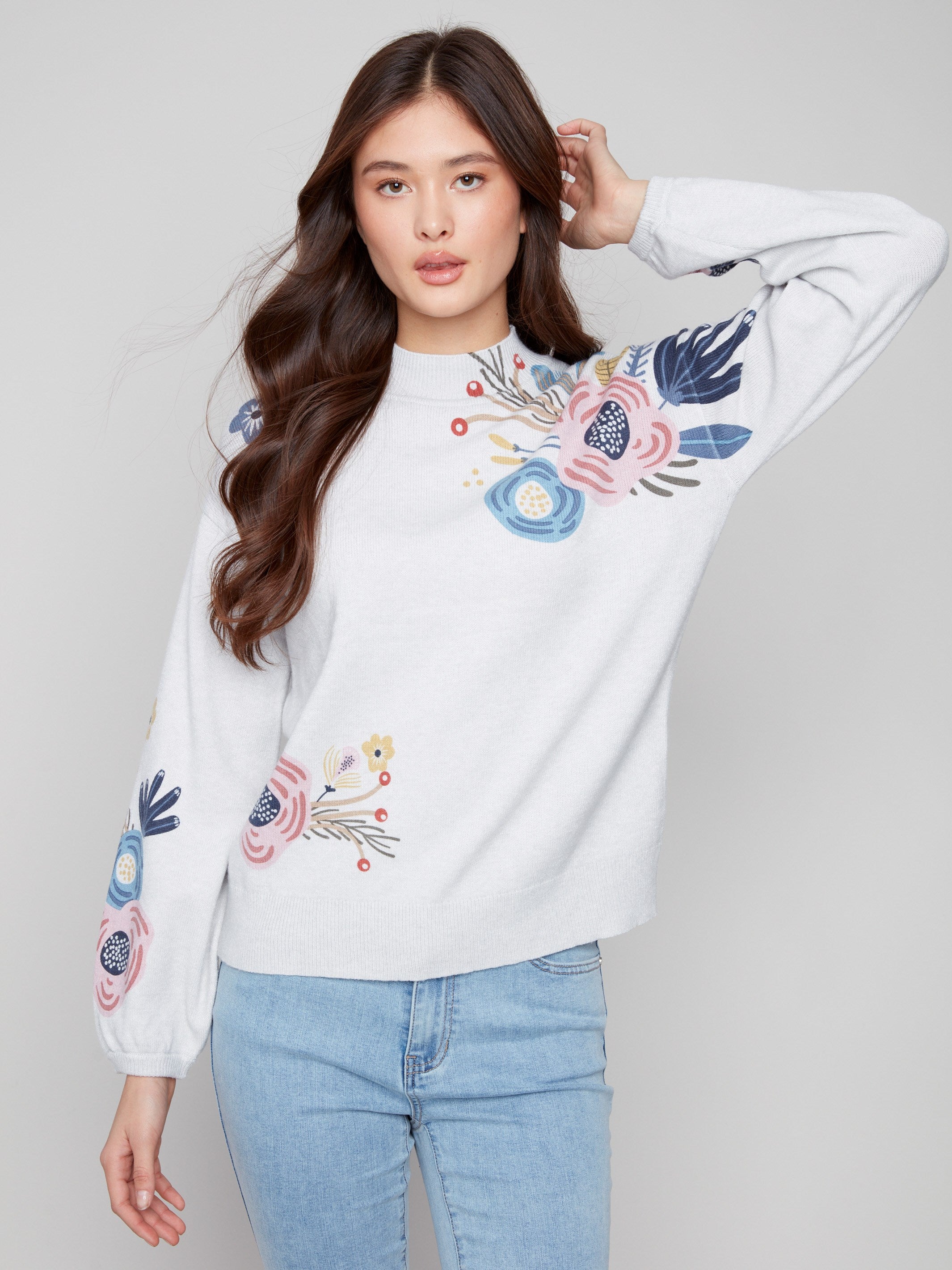 Elegant light grey sweater showcasing a mock neck and intricate floral designs on the sleeves by Charlie B.