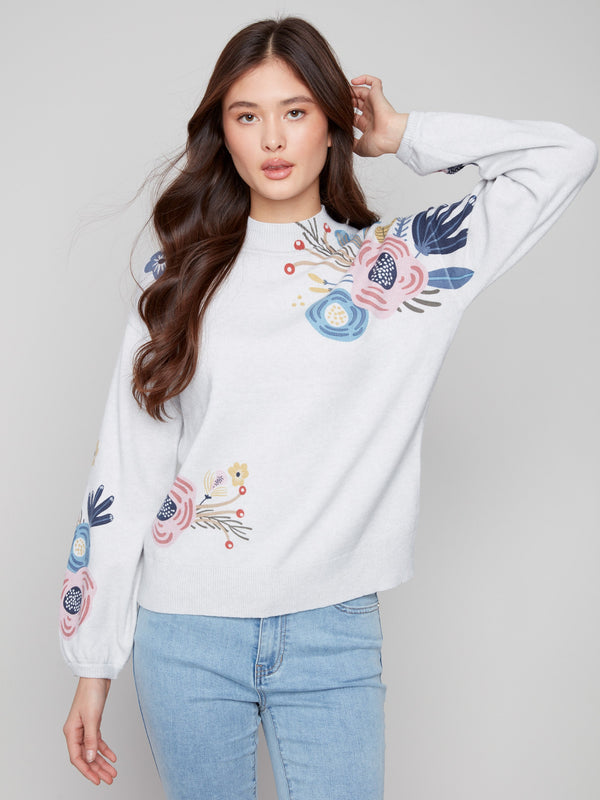 Elegant light grey sweater showcasing a mock neck and intricate floral designs on the sleeves by Charlie B.