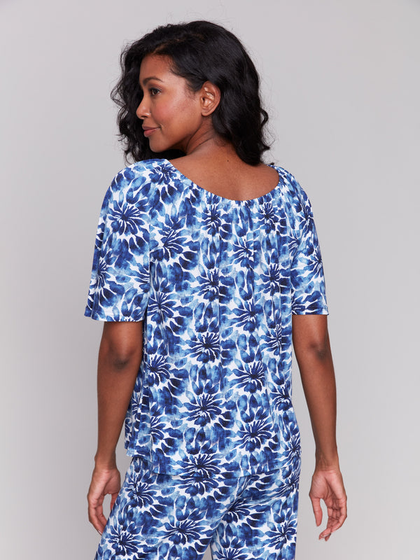 Chic blue top showcasing a round neckline and florals by Charlie B.