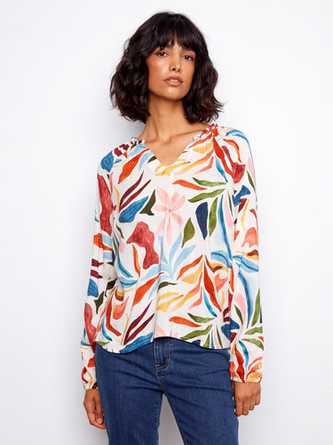 Colorful blouse with a notched neckline and vibrant floral pattern, perfect for adding a touch of elegance to any outfit by Charlie B.