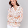 Papaya blouse with lace trim at neckline and cuffs, showcasing geometric floral prints by Charlie B.