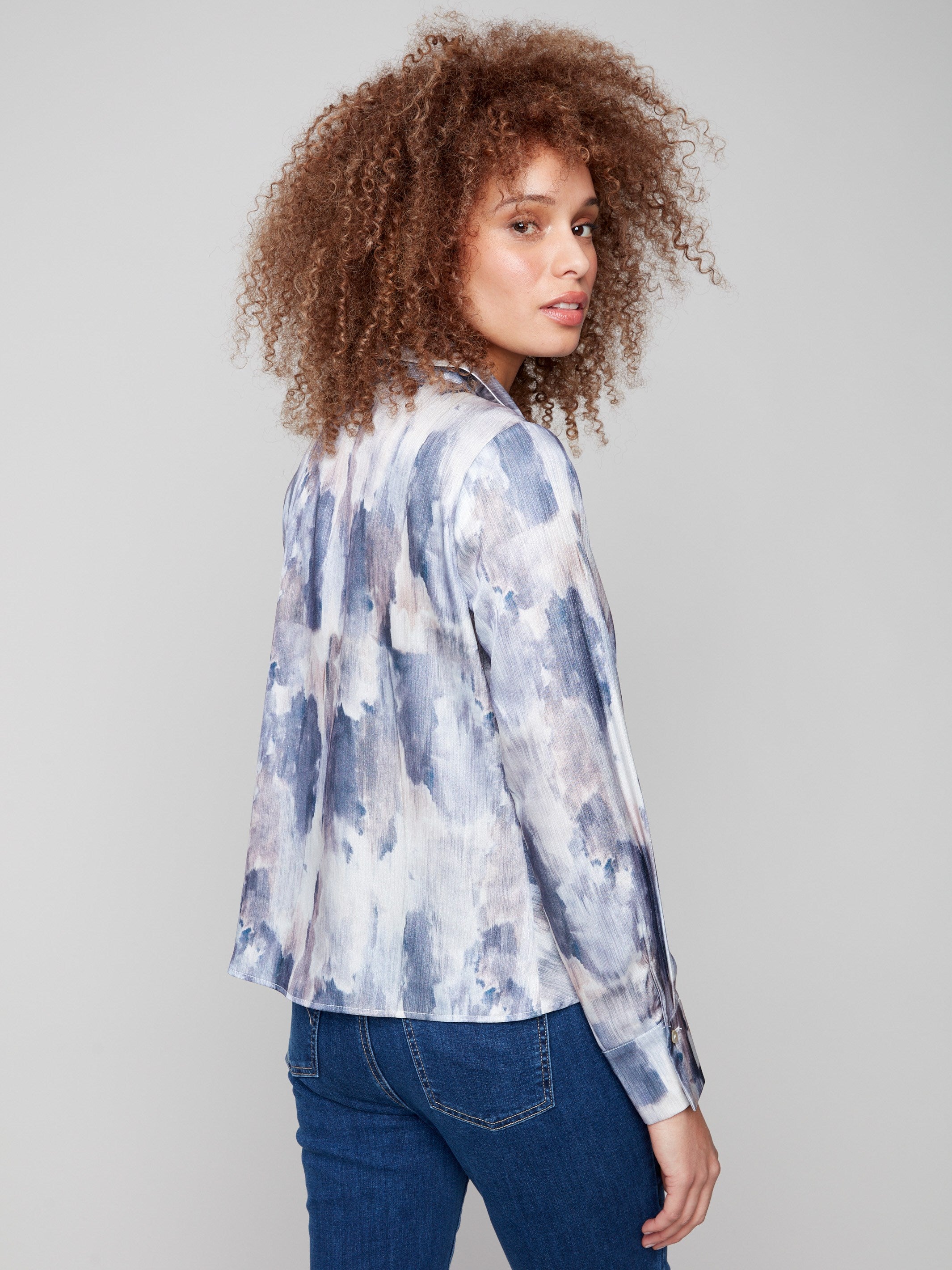 Stylish long sleeves add sophistication to this abstract patterned satin shirt with a twist by Charlie B.