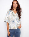 Floral blouse with a Hawaiian print, featuring short sleeves with button tabs and chest pockets by Charlie B.