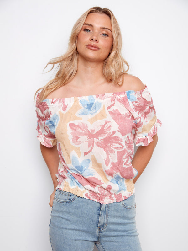 Vibrant floral pattern enhances this off-the-shoulder blouse, perfect for casual outings by Charlie B.