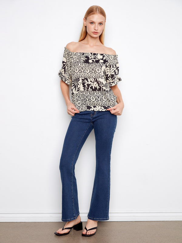 Flutter sleeves add to the charm of this off-the-shoulder top, creating an effortlessly fashionable look by Charlie B.