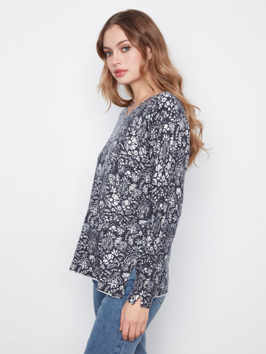 Stylish floral blouse showcasing side slits at the cuffs, offering a unique touch to this relaxed fit design. By Charlie B.