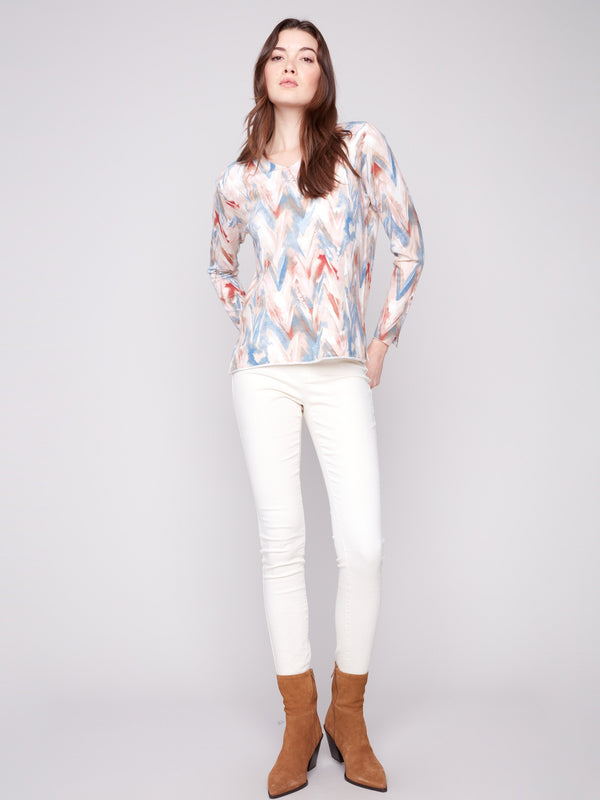 Featuring side slits at cuffs and hem, this sweater showcases a vibrant chevron design for added flair by Charlie B.