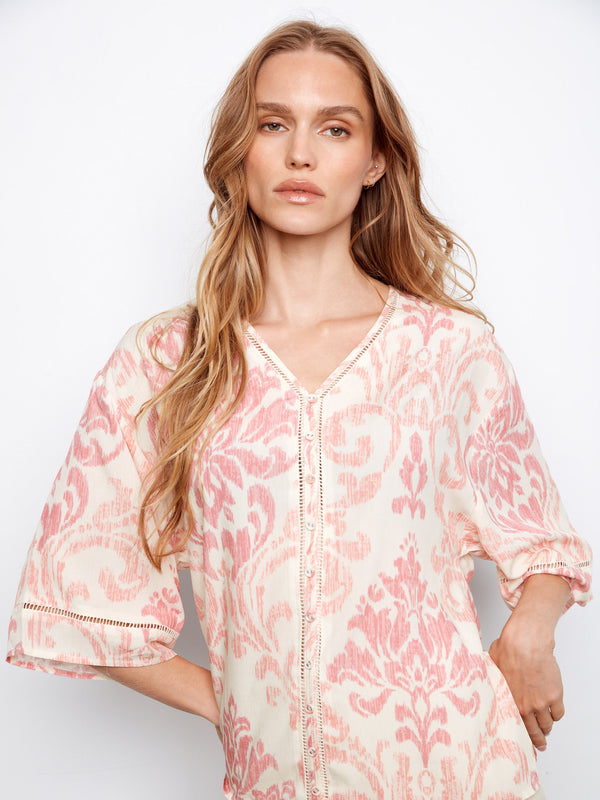 Blouse with button-front detail in an abstract pink and white pattern, featuring a v-neck by Charlie B.