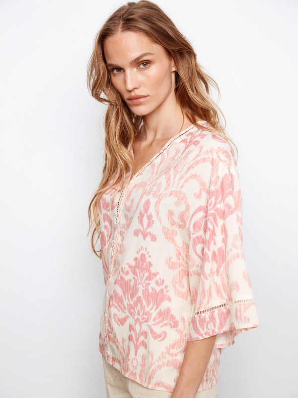 V-neck blouse showcasing a pink and white abstract pattern with wide elbow sleeves for a relaxed fit by Charlie B.