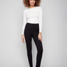 Black pants featuring a skinny fit and styled with a white top, highlighting the elastic waistband by Charlie B.