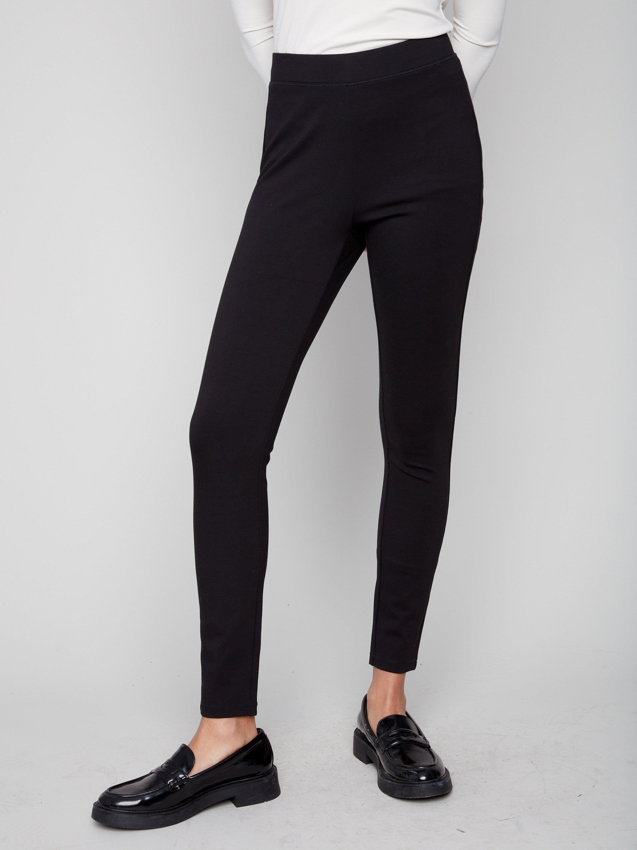 Slim-leg black pants paired with a white top, showcasing the back stitch detail for added style by Charlie B.