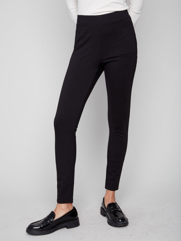 Slim-leg black pants paired with a white top, showcasing the back stitch detail for added style by Charlie B.