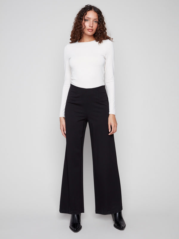 Black pants with a flattering wide-leg silhouette, offering both comfort and style for versatile wear, by Charlie B.