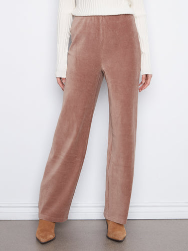 Taupe corduroy pants featuring stretch fabric, paired elegantly with a white ribbed sweater by Charlie B.