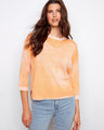 Soft orange top with a crew neckline, featuring a stylish reversed print. Perfect for casual outings. Made by Charlie B.