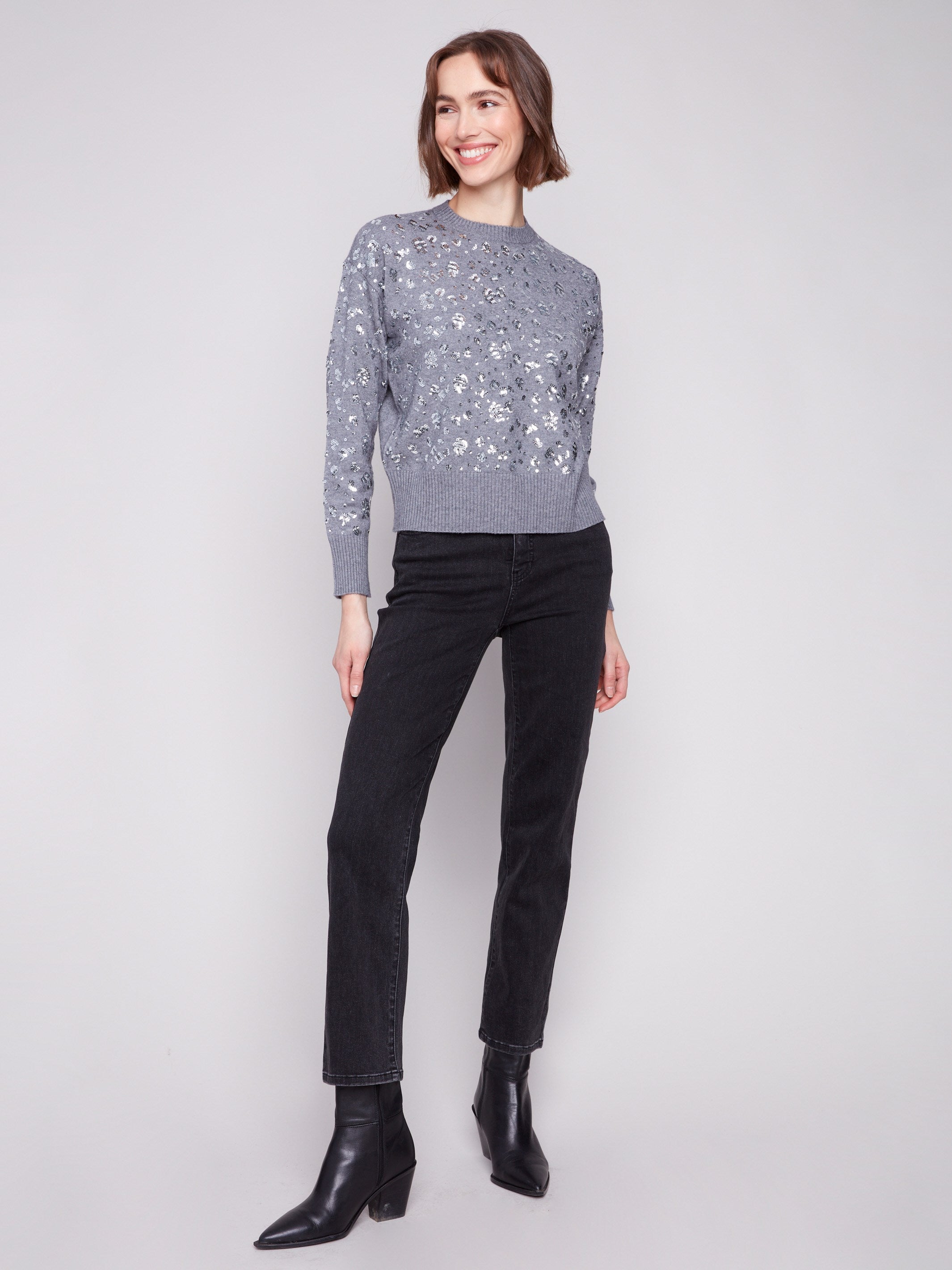 This slightly cropped sweater in dark grey showcases a sparkling sequin pattern, perfect for a chic look by Charlie B.