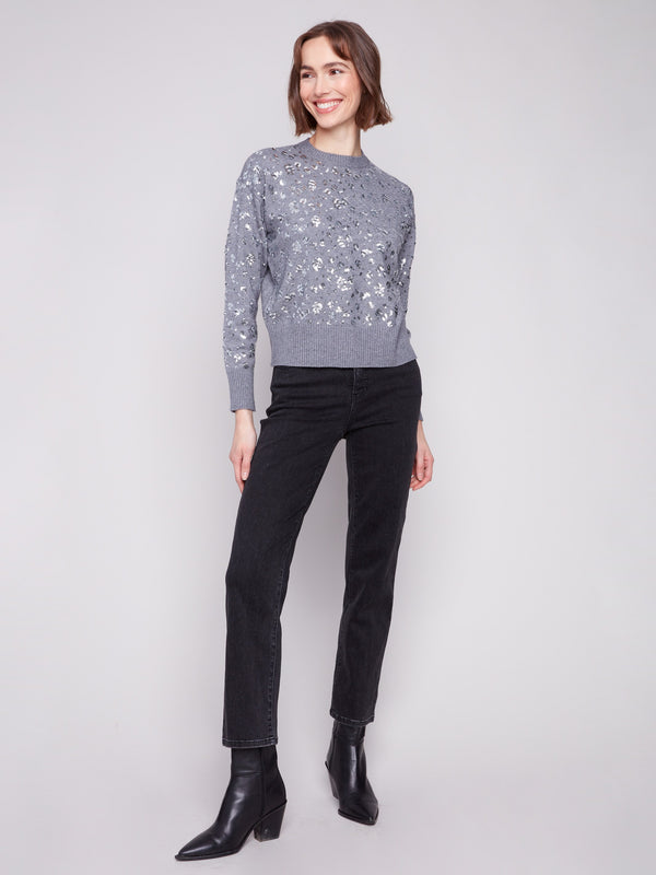 This slightly cropped sweater in dark grey showcases a sparkling sequin pattern, perfect for a chic look by Charlie B.