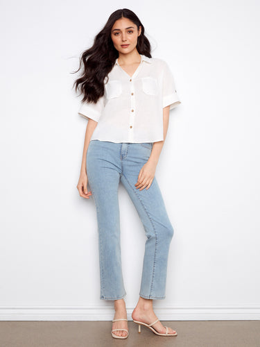 This stylish white shirt has short sleeves with button tabs, adding a versatile touch to your casual wardrobe by Charlie B.