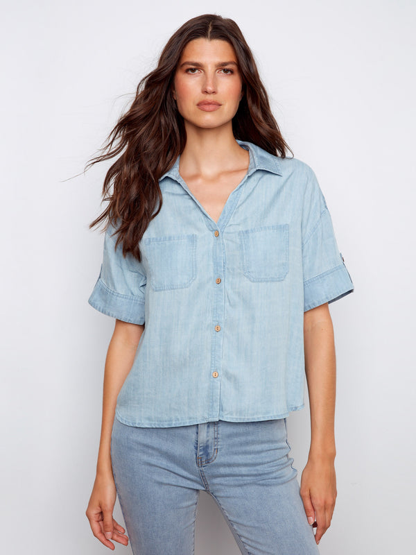 Light blue blouse with button tabs on short sleeves and patch pockets, crafted in Tencel by Charlie B.