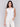 Stylish white crochet garment adorned with flowers by Charlie B.