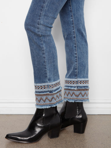 Slim-fit medium blue jeans with an eye-catching embroidered hem detail, combining fashion and functionality by Charlie B.