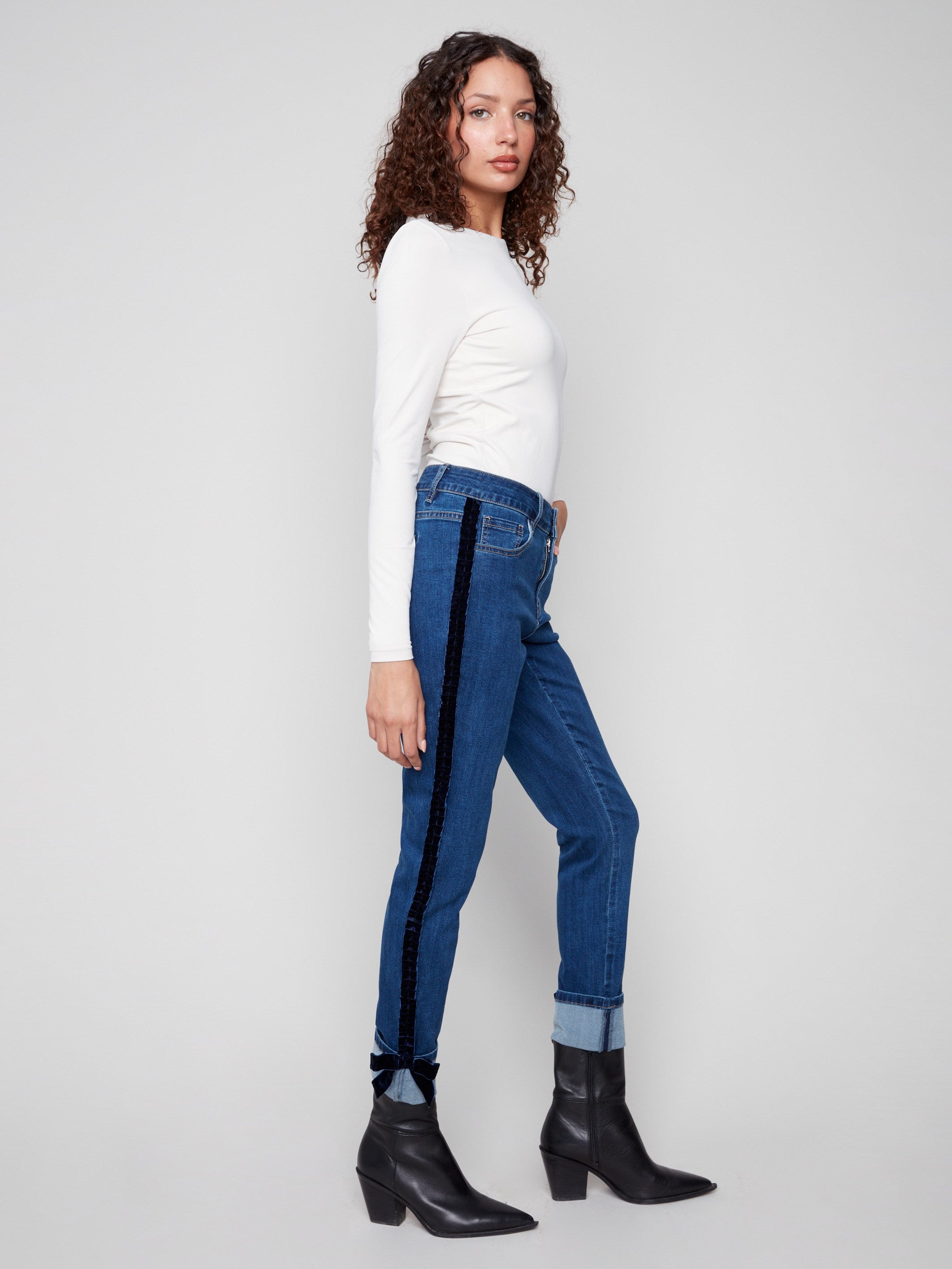 Ankle-length indigo jeans with velvet bow trim along the side seams for added flair by Charlie B.