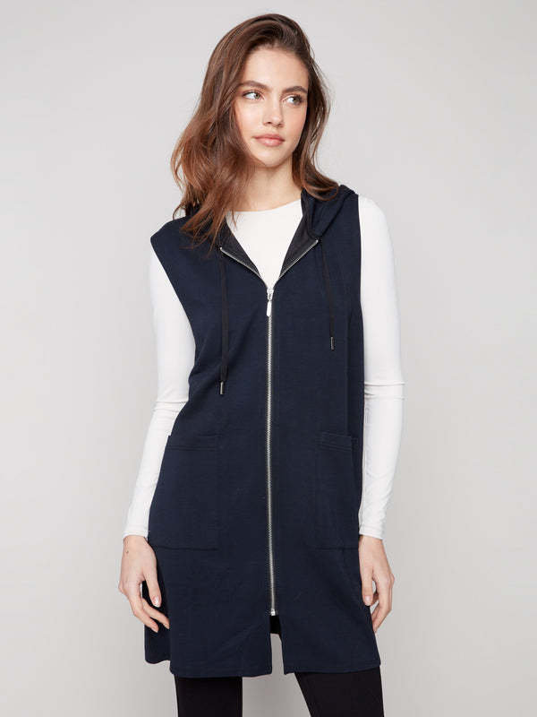 Elegant sleeveless vest in black, highlighted by its mid-thigh length and convenient patch pockets by Charlie B.