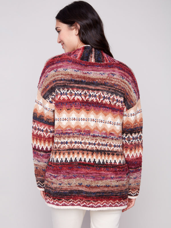 The cardigan's drop shoulder design enhances its relaxed fit, paired with a striking geometric pattern by Charlie B.