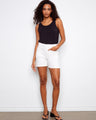 White shorts with a five-pocket design paired with a black tank top, showcasing casual elegance. By Charlie B.