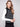 Stylish black sweater vest adorned with snap button details and elegant white horizontal stripes by Charlie B.