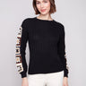 Elegant black sweater featuring intricate crochet sleeves, perfect for a stylish look by Charlie B.