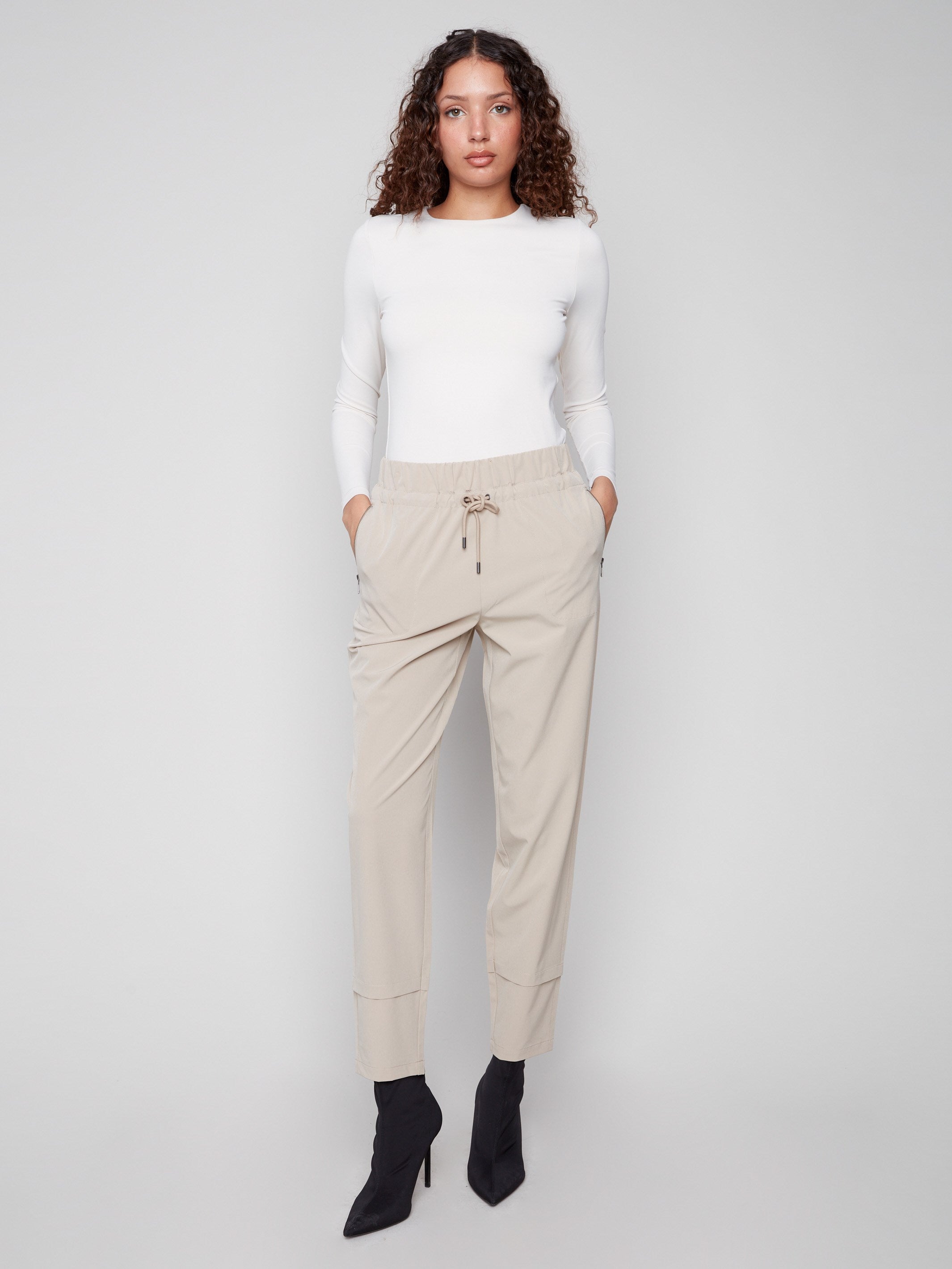 Greige slim-leg techno pants with a relaxed fit, featuring pull-on style and side zip pockets for convenience by Charlie B.