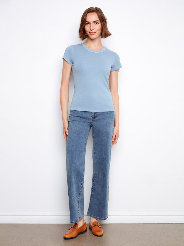 This versatile blue top is crafted with a ribbed texture and semi-fitted cut, enhancing your silhouette effortlessly. By Charlie B.