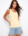 Yellow tank top featuring a scoop neckline, paired with denim shorts. Perfect for casual outings. Designed by Charlie B.