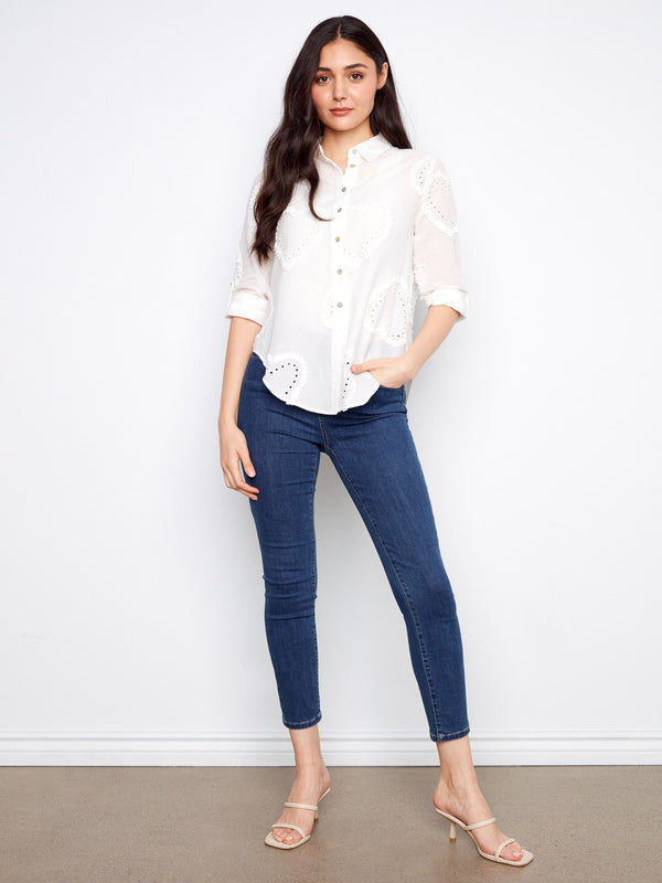 Charming eyelet details create a unique texture on this fashionable white shirt, making it stand out. By Charlie B.