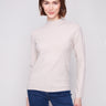 Oat sweater with a mock neck, paired with blue jeans, showcasing the slim fit design for a modern look by Charlie B.