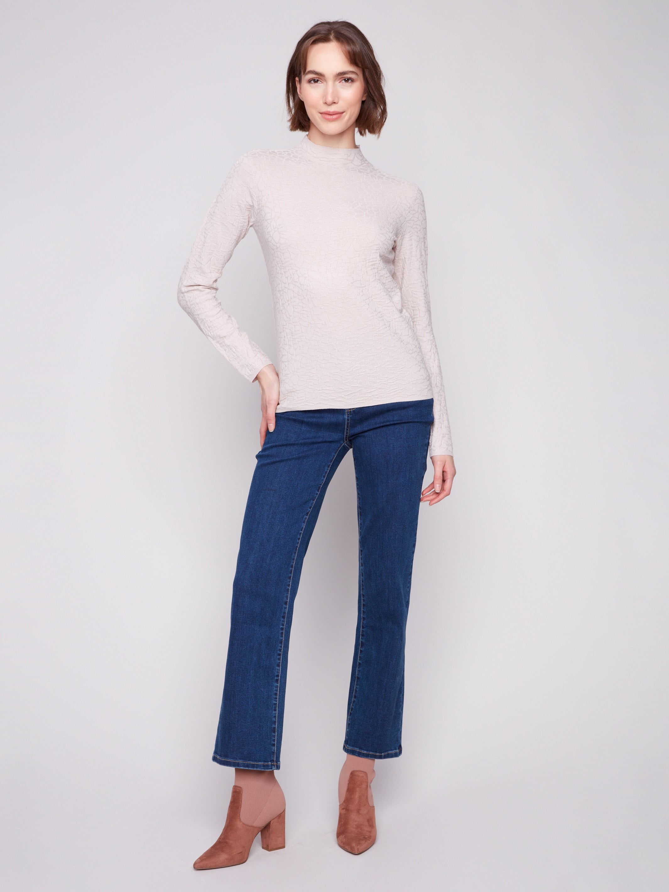 Textured oat sweater styled with blue jeans and boots, highlighting the chic mock neck detail by Charlie B.