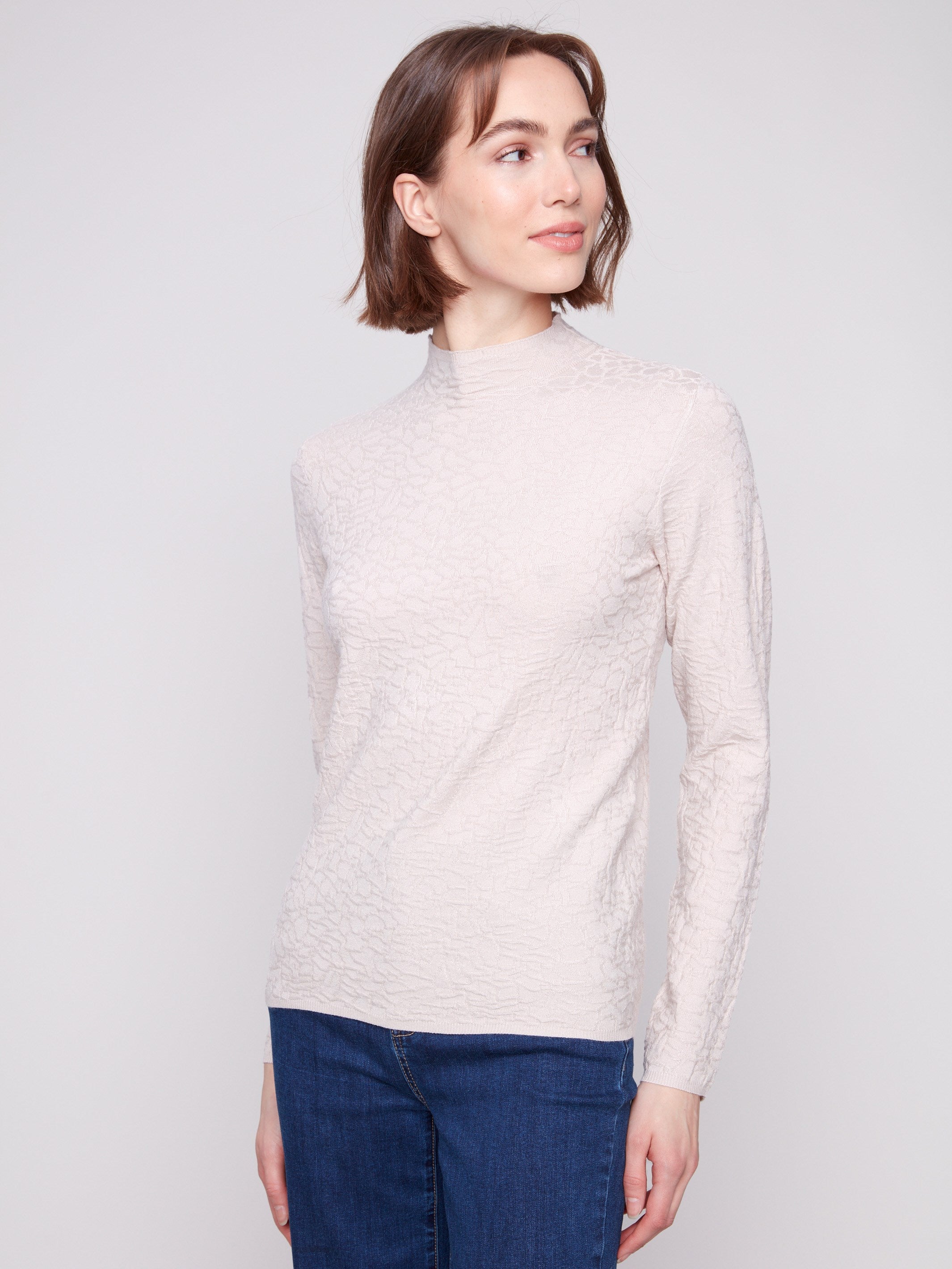 Long-sleeve oat sweater in textured fabric, paired effortlessly with blue jeans for a sleek appearance by Charlie B.