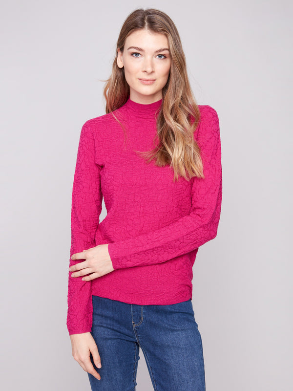 Sophisticated slim fit hibiscus sweater in a vibrant hue, complemented by blue jeans by Charlie B.
