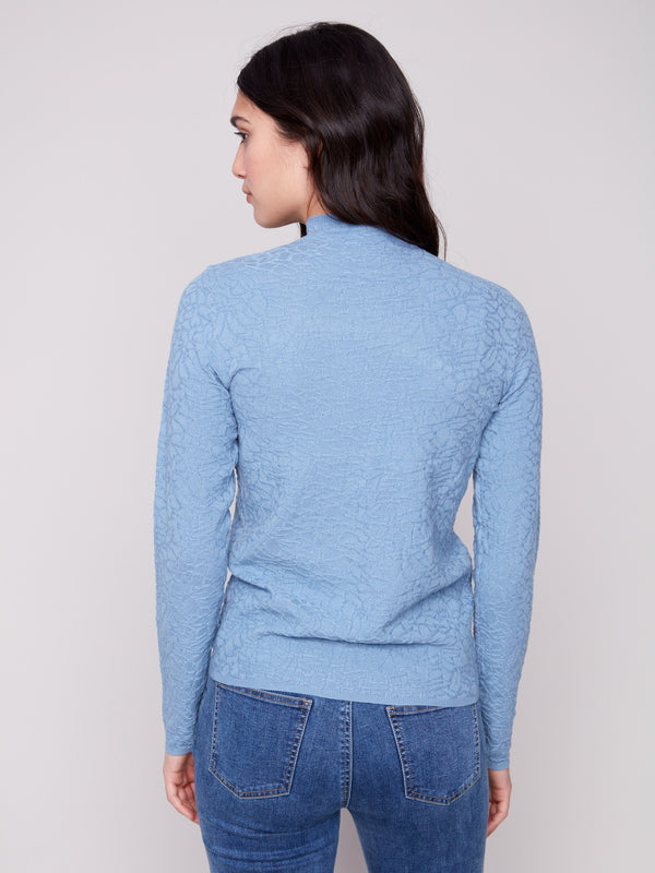 Slim fit Oxford blue sweater styled with denim, highlighting its chic and modern appeal by Charlie B.