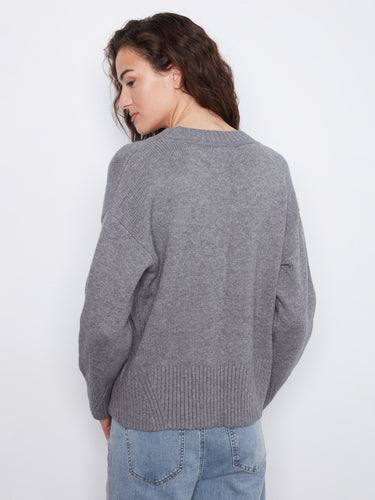 Stay warm in this elegant grey knit sweater with its classic long sleeves and relaxed fit by Charlie B.