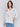 White V-neck knit top with colorful floral appliqués, featuring drop shoulders, by Charlie B.