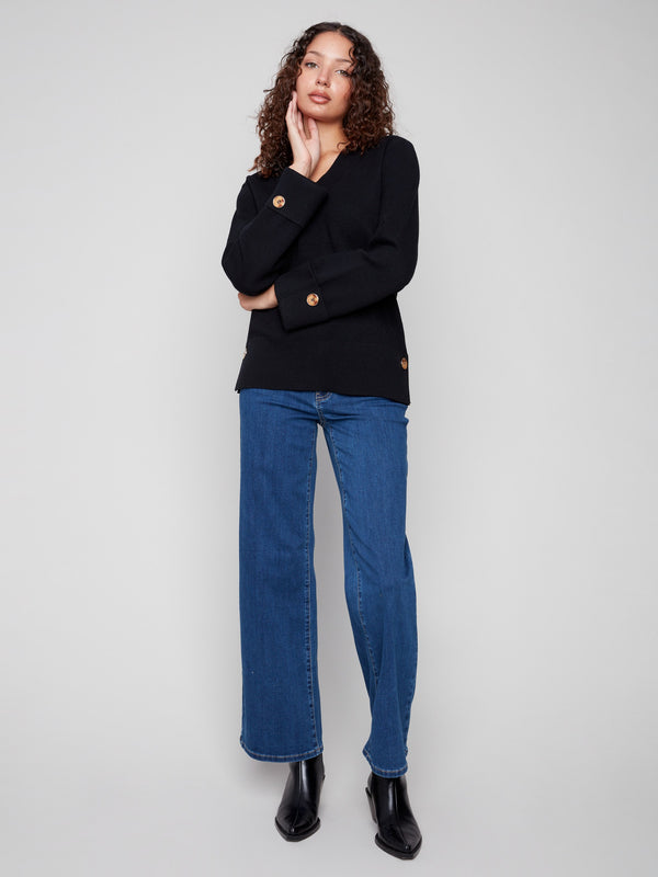 Chic black sweater showcasing buttons at sleeves and sides, ideal for versatile styling by Charlie B.